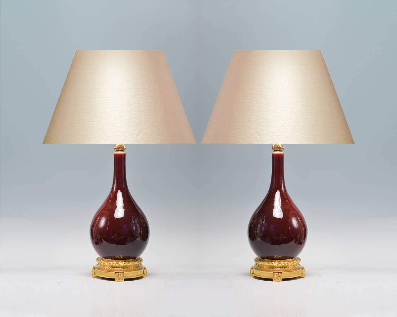 Pair of copper red-glazed porcelain lamps with gilt bronze bases
(Lampshade not included).