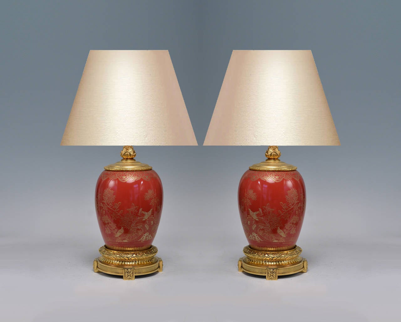 Pair of ormolu-mounted red porcelain lamps with fine painted flower blossom and birds decoration.
(Lampshade not included).