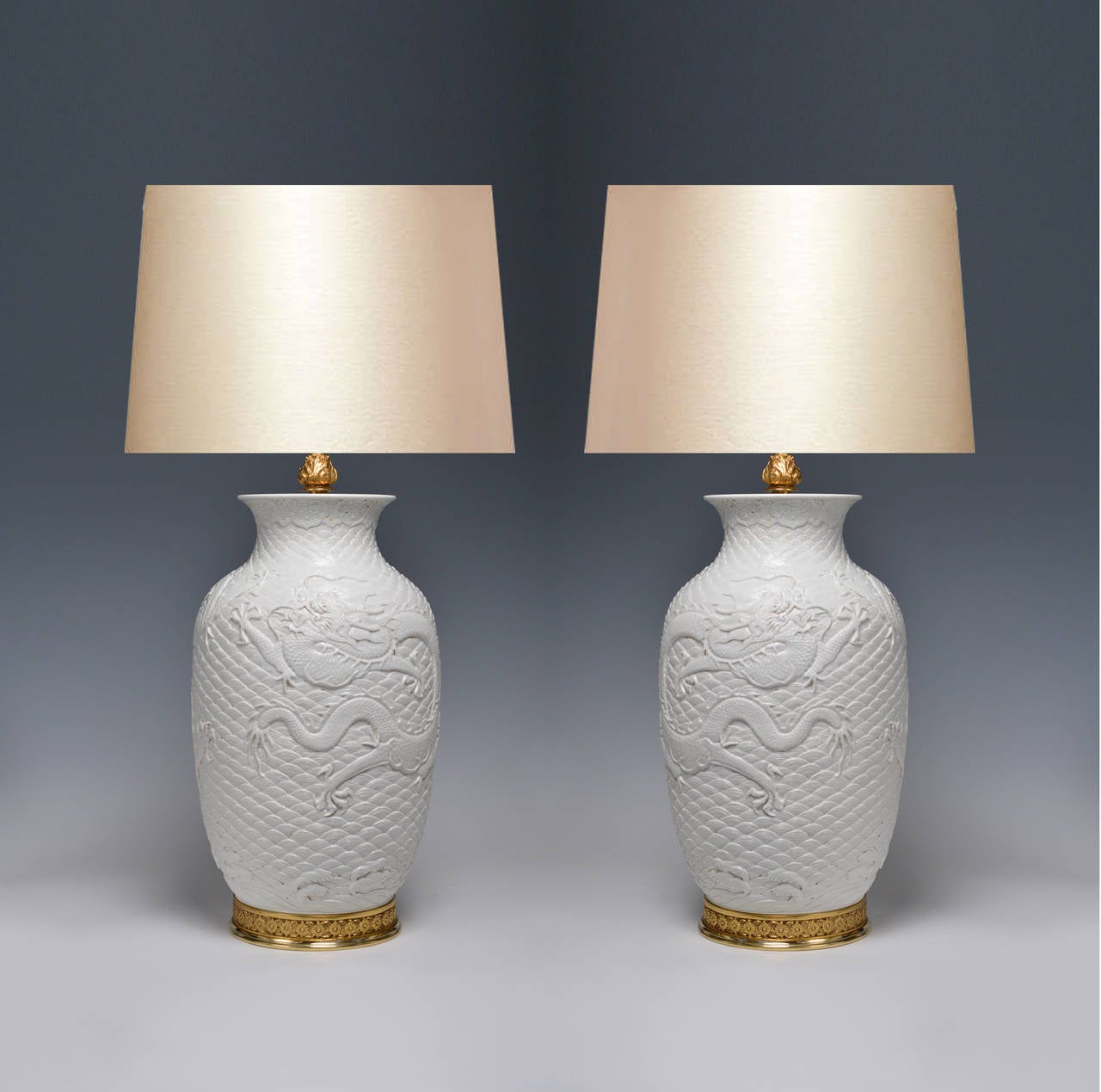 Pair of white porcelain lamps with gilt bases, with dragon decoration; 19.5