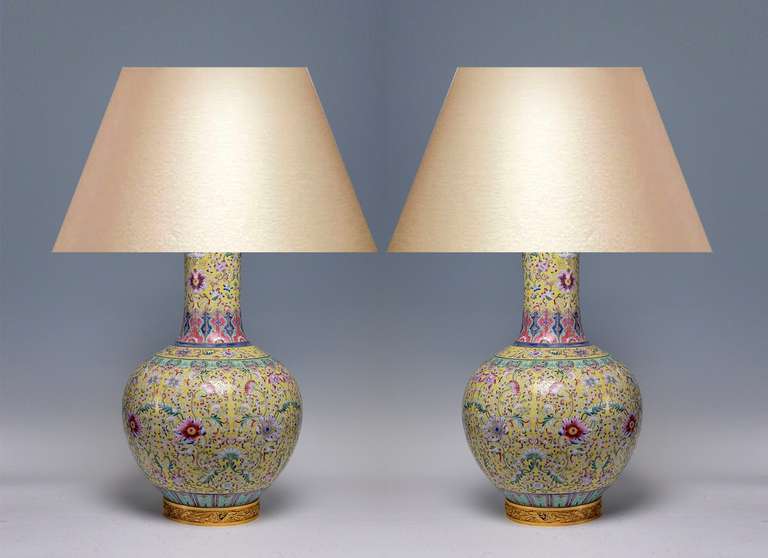 Die gelbgeschliffenen Flaschenvasen aus Porzellan mit vergoldeten Bronzefüßen sind als Lampen montiert.
(Lampenschirm nicht enthalten).