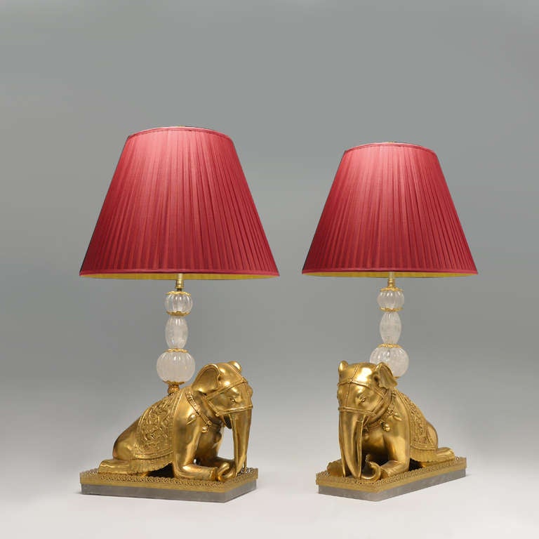 Fine cast gilt bronze figures of the kneeled elephants mounted as lamps, embellished with rock crystals, circa 1920.
(Lampshade not included).