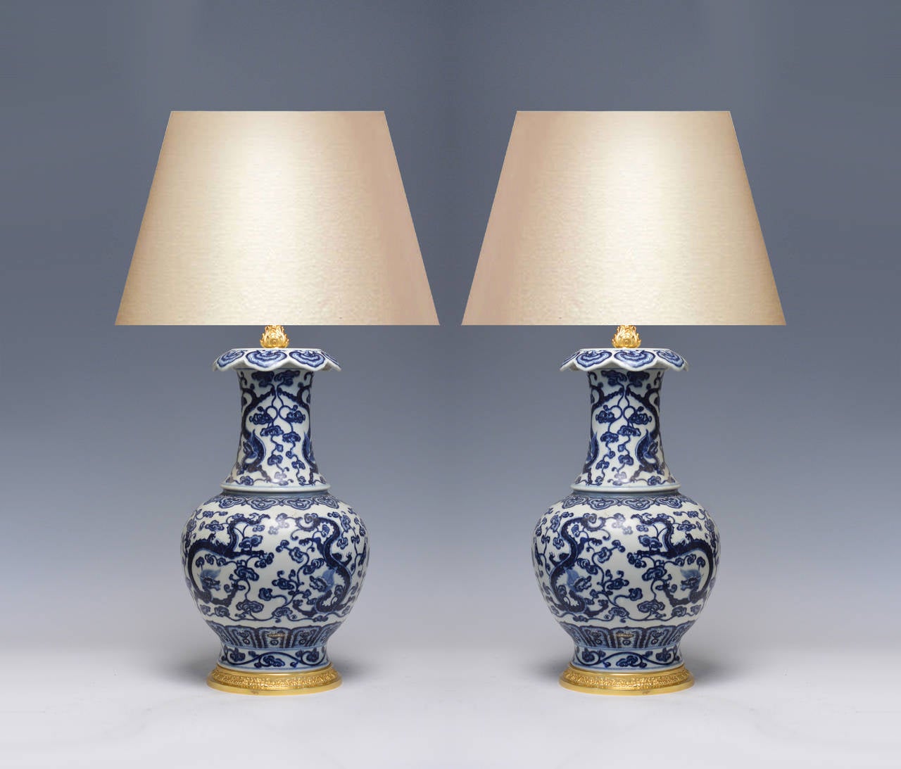 Pair of fine painted blue and white porcelain lamps with dragon and floral scroll decoration, gilt brass bases. Measure: 18