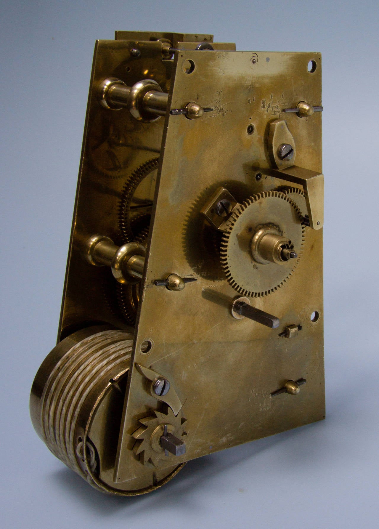 The 14” dial is made from a single sheet of hammered cast brass, which is engraved with Roman hour markers inside a single line minute-track with Arabic numerals outside at every five minutes. This style of dial layout was rarely used on domestic