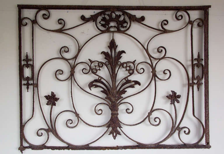 Mid 18th century iron grille believed to have come from a French Normandy Chateaux. Wrought iron swirls with applied cast iron ornamentation.