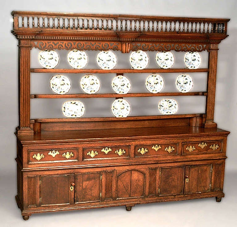 Superb and unusual 18th c. Welsh oak dresser, the rack with spindle gallery and pierced scrollwork frieze over a lower section fitted with drawers over cupboard doors.  This piece of  Welsh oak furniture is notable for its distinctive reddish brown