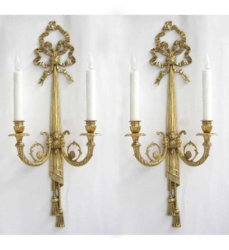 A pair of George III style brass bowknot and swag two-light sconces in the Adam taste.
