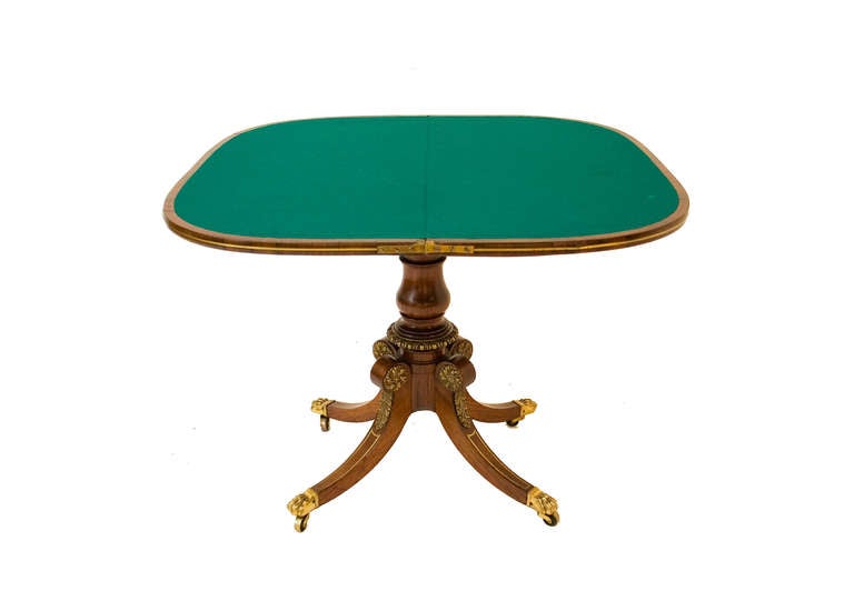 A Regency brass-inlaid rosewood D-form swivel-top card table with turned pedestal base and lyre mounted frieze.