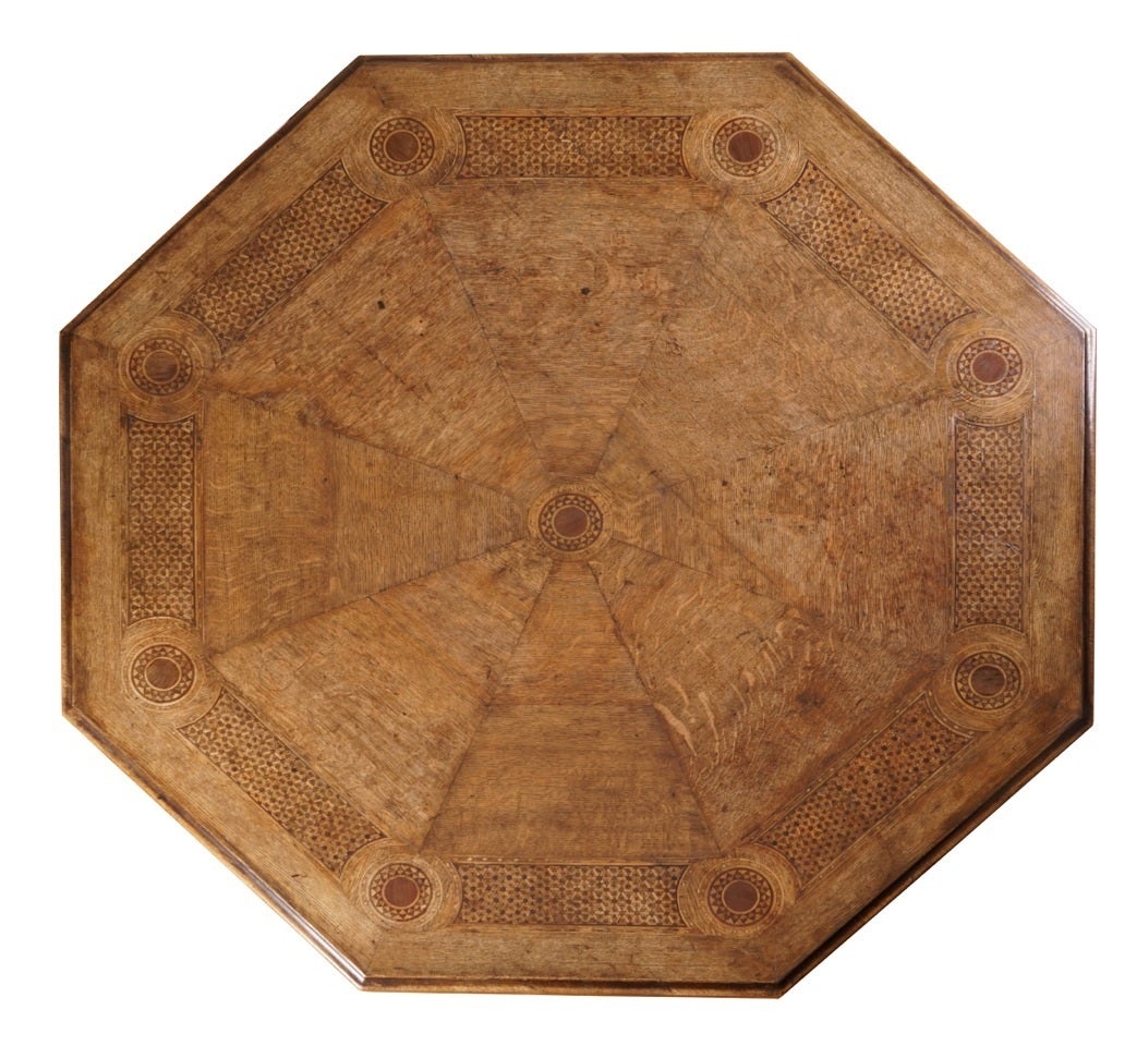 By John Douglas of Chester, England.

The centre table of octagonal form, the oak segmented top with an intricate wide border of holly and purple heart lattice work and purple heart roundels, above a shaped frieze with rectangular purple heart