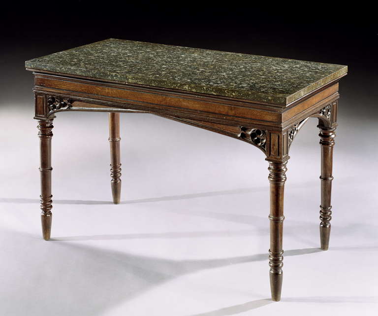 A rare pair of Regency period oak and brown oak side tables with Egyptian granite tops. Each with a moulded frieze veneered with quarter sawn brown oak panels above a gothic arched apron carved with quatrefoils supported on four ring turned legs