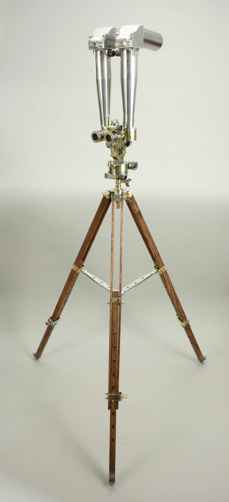 A great pair of binoculars known as ‘Binocular Periscope’, 'Trench Binoculars', ‘Battery commander’s telescope’ or ‘Donkey Ear Binoculars’. The binocular periscope is mounted on an old wooden tripod and the whole apparatus is stripped of paint and