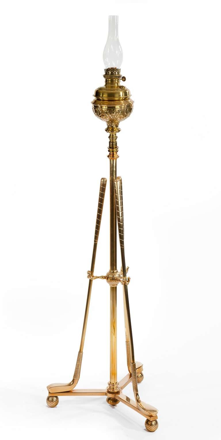 An excellent quality brass standard lamp with tripod base supported on three balls with the pattern of 19th century gutta percha golf balls. Mounted on the base are three long nose golf clubs, Putters supported in the centre with three small