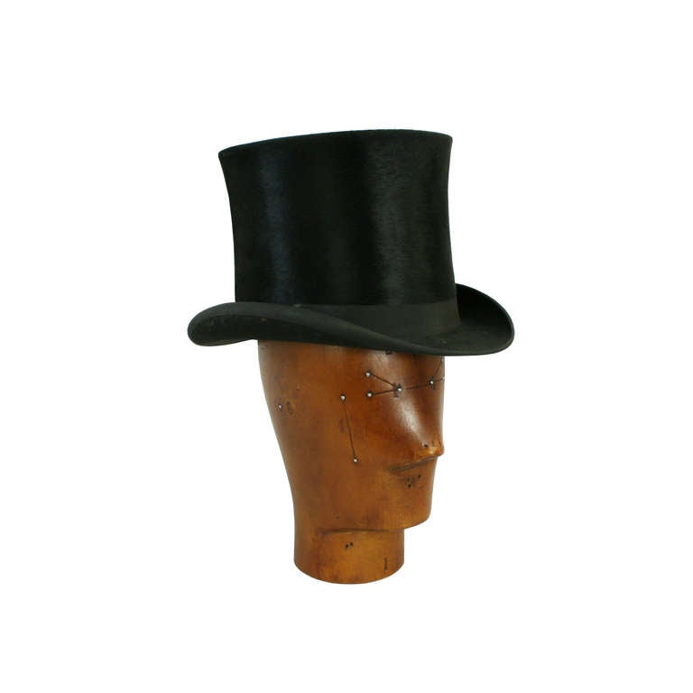 A very fine silk top hat made for Norton & Son, Broad Street, Hereford. The ‘topper’ is in excellent wearable condition with an external black band and bow. The interior white satin lining is in excellent clean condition with a royal crest and