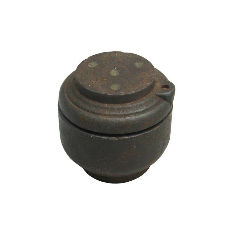 A cast iron golf ball mould used for the manufacturing of mesh pattern gutta-percha golf balls. The casing has got a locating pin to ensure the correct alignment of the pattern. 
The gutta-percha was heated and loosely rolled into a ball shape. The