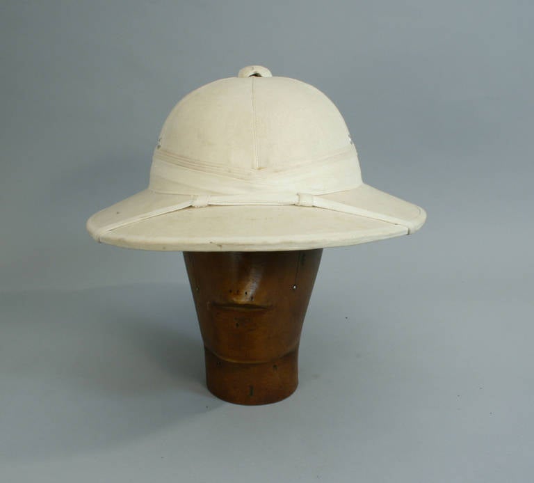 Pith Helmet, Solar toupie feet.
A good shaped white solar toupie feet (also known as a pith helmet, safari helmet or topi) in nice condition but no inner head fittings. The toupie feet is a lightweight cloth-covered helmet designed to shade the