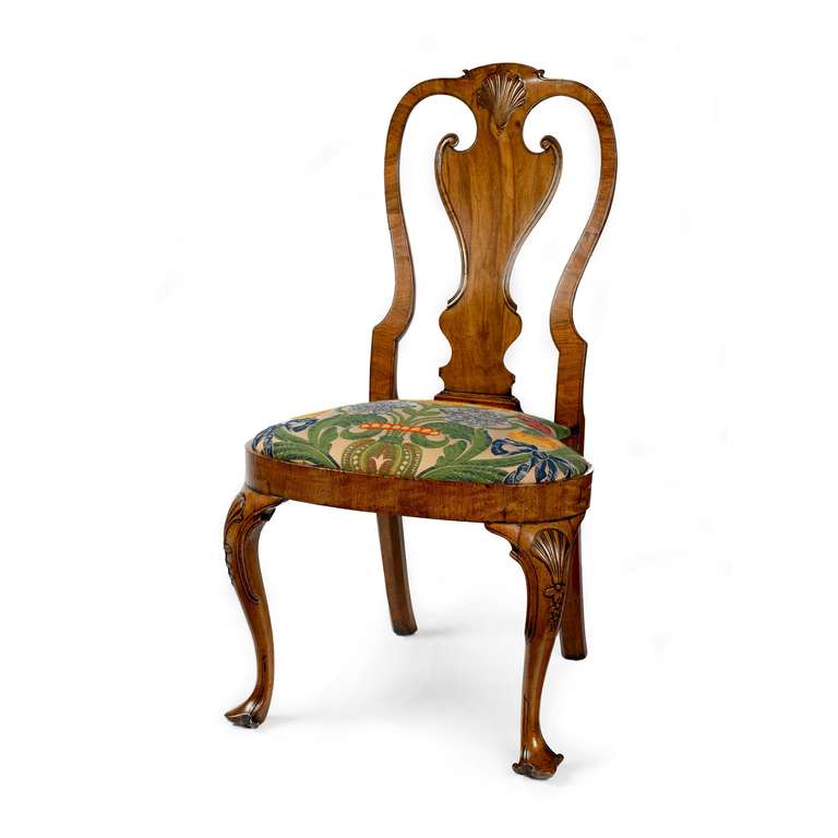 A fine pair of Irish George II walnut side chairs of compact proportions and excellent colour and patina. The curved, moulded side rails joined by a scrolled top rail with central carved shell following down to a vase shaped central splat, with