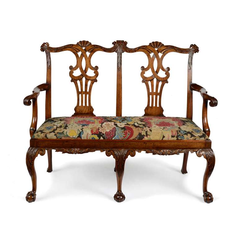 A superb George II mahogany chairback settee attributed to Giles Grendey. Of double chairback form , with a carved scrolling top rail with acanthus leaf carving flowing into a tight paper scroll to each of the three vertical rail tops.

The