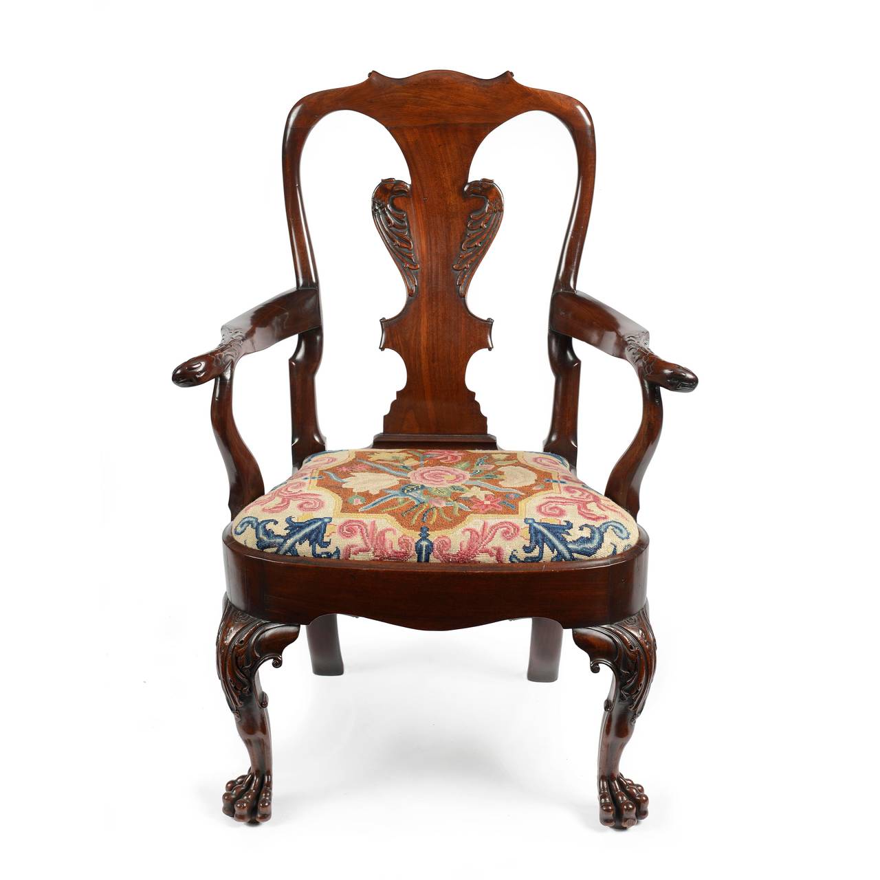 A fabulous pair of Irish George II mahogany library armchairs, retaining fine original colour and patina. The curved tapering backs with a serpentine shaped top rail with fine carved scrolls to each point. The central vase shaped splat accentuated
