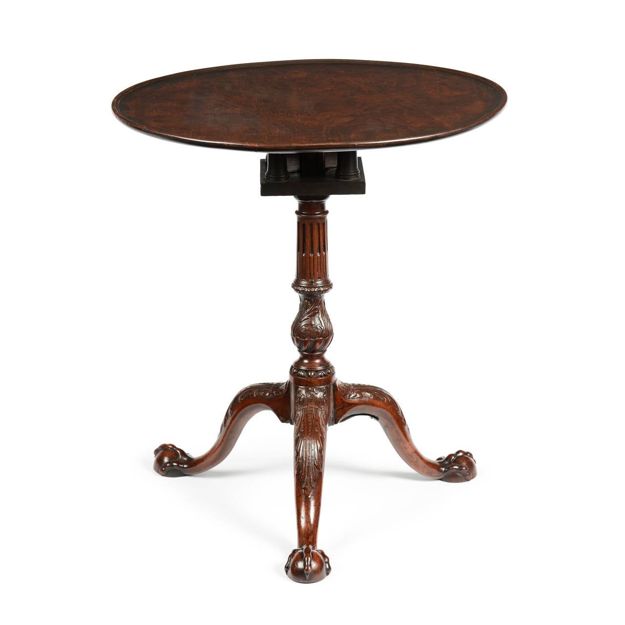 A superb George II carved mahogany tripod table retaining excellent original colour and patina. Thee extremely well figured top with a dished edge, supported by a revolving birdcage action. The column of tapering form, stop fluted to the top, with