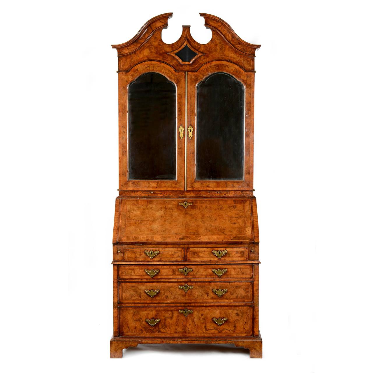 A fine George I figured walnut & feather banded bureau bookcase. The bookcase section with swan neck pediment, of shaped cavetto section, cross & feather banded with and inset glass lozenge panel set within a bold cross grain moulding. The