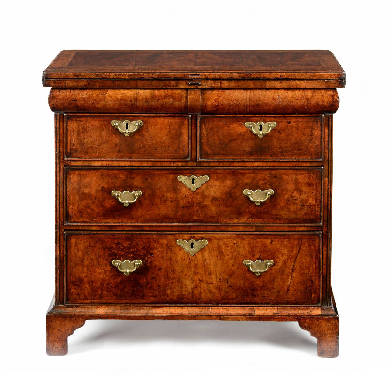 A fine and very rare George I walnut and feather banded bachelor chest with an unusual cushion waist. The top with a cross and feather banded top laid with veneers in a double book matched fashion. Opening the top reveals a very similar layout of