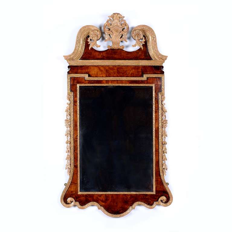 An elegant, fine quality George II figured walnut and giltwood wall mirror of excellent original colour and patina. The rectangular, bevelled, mirror plate bordered by carved gilt wood outline, with a walnut body, again bordered by a carved gilt