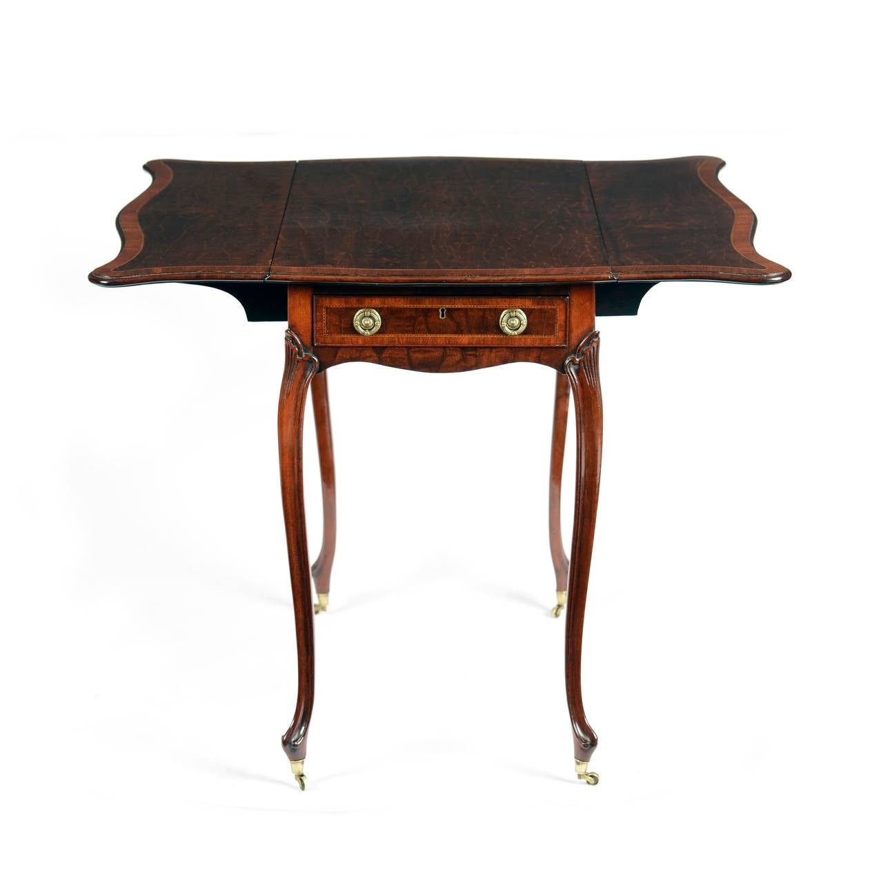 A rare George III “crocodile” mahogany and tulipwood banded butterfly top pembroke table, attributed to Thomas Chippendale. The fabulously figured top of serpentine shape to all for sides forming a “butterfly” wing, with chequer stringing and