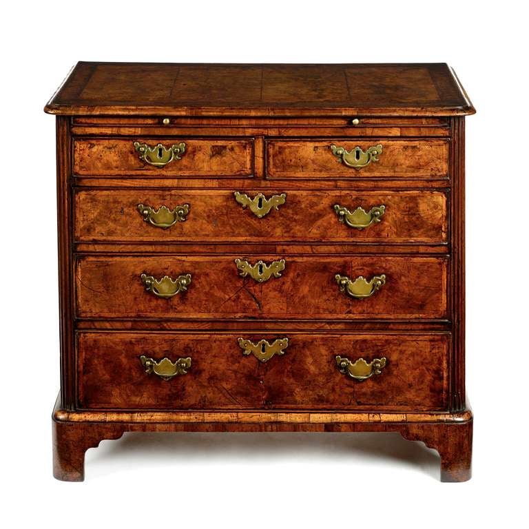 A fine George II figured walnut compact chest with brushing slide, of excellent colour and patina. The top of rectangular form with applied cross-grained moulded edge, the front corners rounded. The top laid with a cross-banding between a broad and