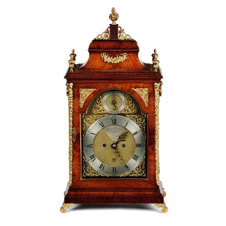 A fine George III figured mahogany double fusee bracket clock by Henry Hopkins, Deptford, London. The mahogany bell top mounted with a floral garland and a central column supported by gilt brass pierced fretwork, topped with a central flame finial