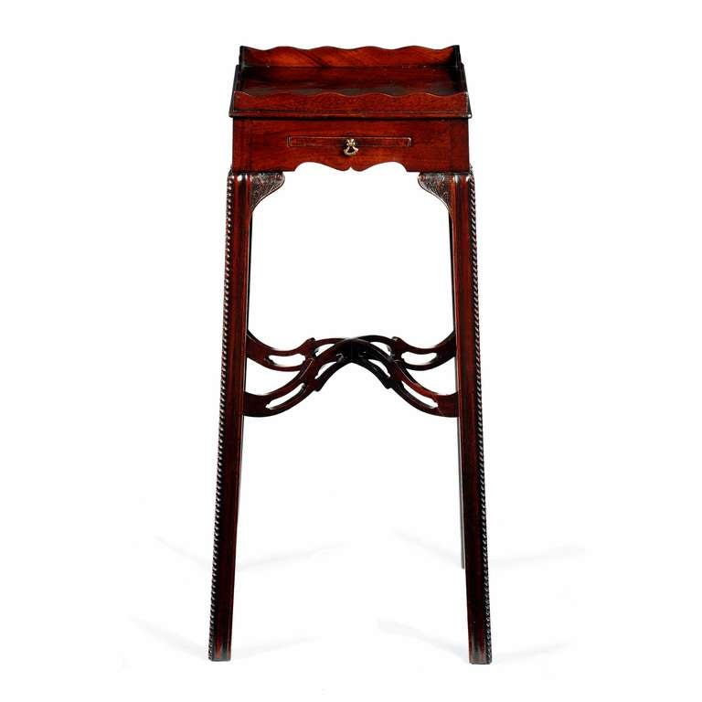 A fine George III Chippendale period Cuban mahogany urn stand. The square top with excellent figuring bordered by an upstanding scalloped gallery, with cock beaded circumference. The frieze with retractable drawer to the front with a small brass axe