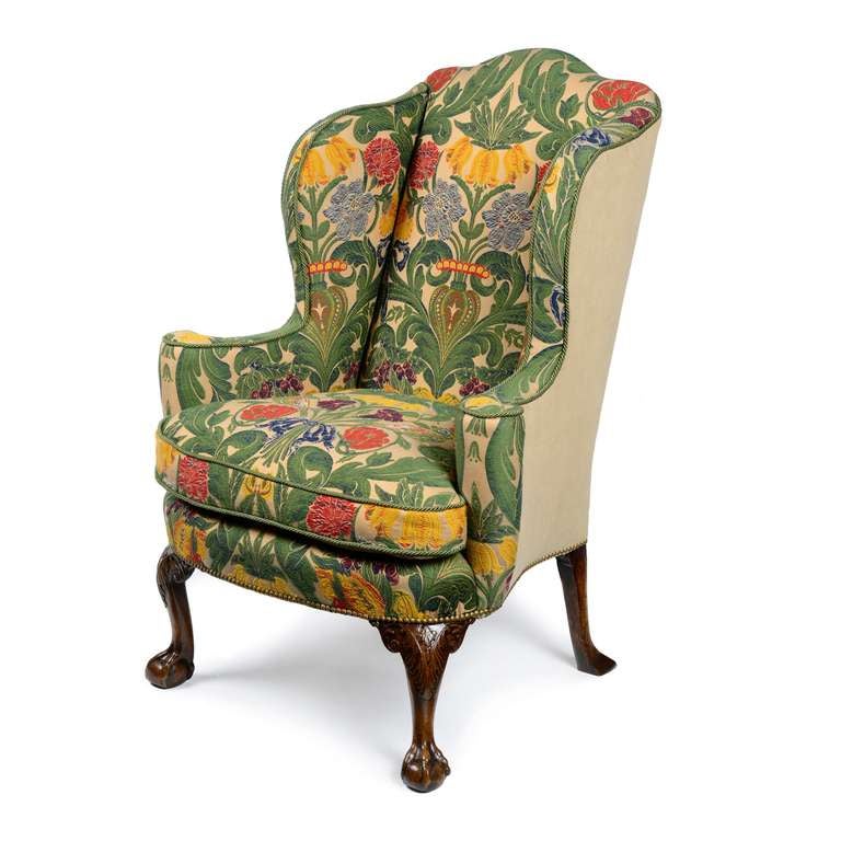 A fine English George II walnut wing back armchair of excellent shape & proportions. The back with serpentine shaped top flanked by out swept side wings, scrolling outwards to form armrests which terminate in an elegant tightly scrolled column. The