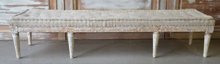 Swedish Gustavian Bench, circa 1810, finished on three sides with leaf rod and floral rosette carvings. Scraped to original cream white finish and upholstered in traditional way in antique hand stitched linen.