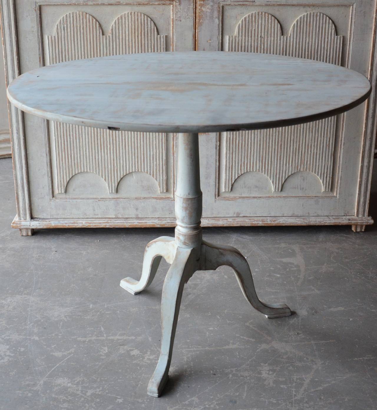 19th century large round tilt top pedestal table in birch wood, Sweden, circa 1850 with turned base supported by beautifully carved legs. Scrape back to traces of its original color blue color.