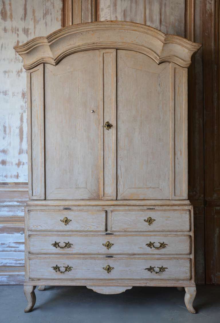 18th century Swedish Rococo Period Cabinet with wonderful arched cornice, original hardware, shaped apron and cabriole legs. Scraped back its original pale blue/grey color features two shelves and a notched spoon shelf in worn blue patina.
Sweden,