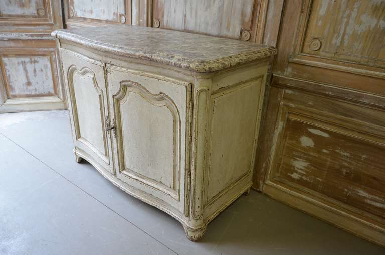 A painted large serpentine front Buffet with marbleized wooden top,
shaped and fielded door panels raised on short cabriole legs.