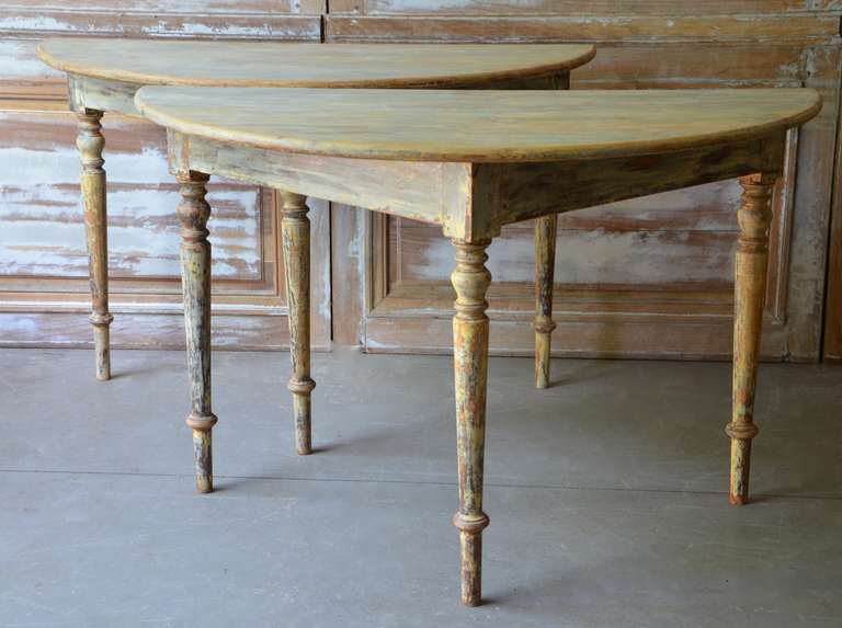 19th century Swedish demi lune tables with deeply angled straight apron and turned, tapered legs scraped back to traces of it's  original color.
Circa 1850, Sweden