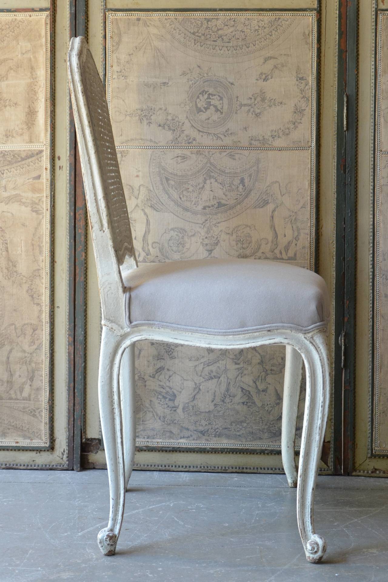 Set of six 19th century, French chairs Louis XV style with flat back called “la Reine” is caned and scalloped frieze carved and raised on cabriole legs. Upholstered in very light bluish/gray linen. Very elegant as well as comfortable,
circa 1880.