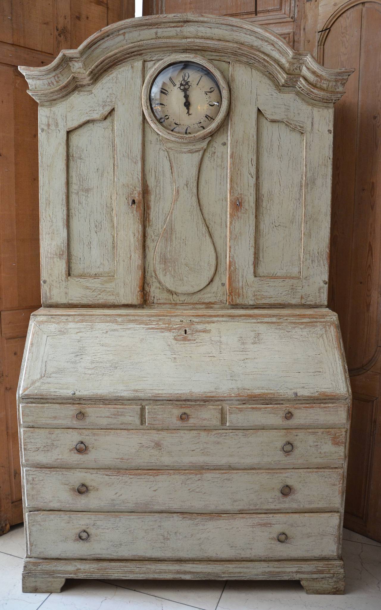 18th century Swedish period Rococo clock secretaire cabinet with wonderful arched cornice, raised panel doors on each side of the clock casing, original hardware, original and rare one hand dial, the earliest one.
Writing surface with several banks