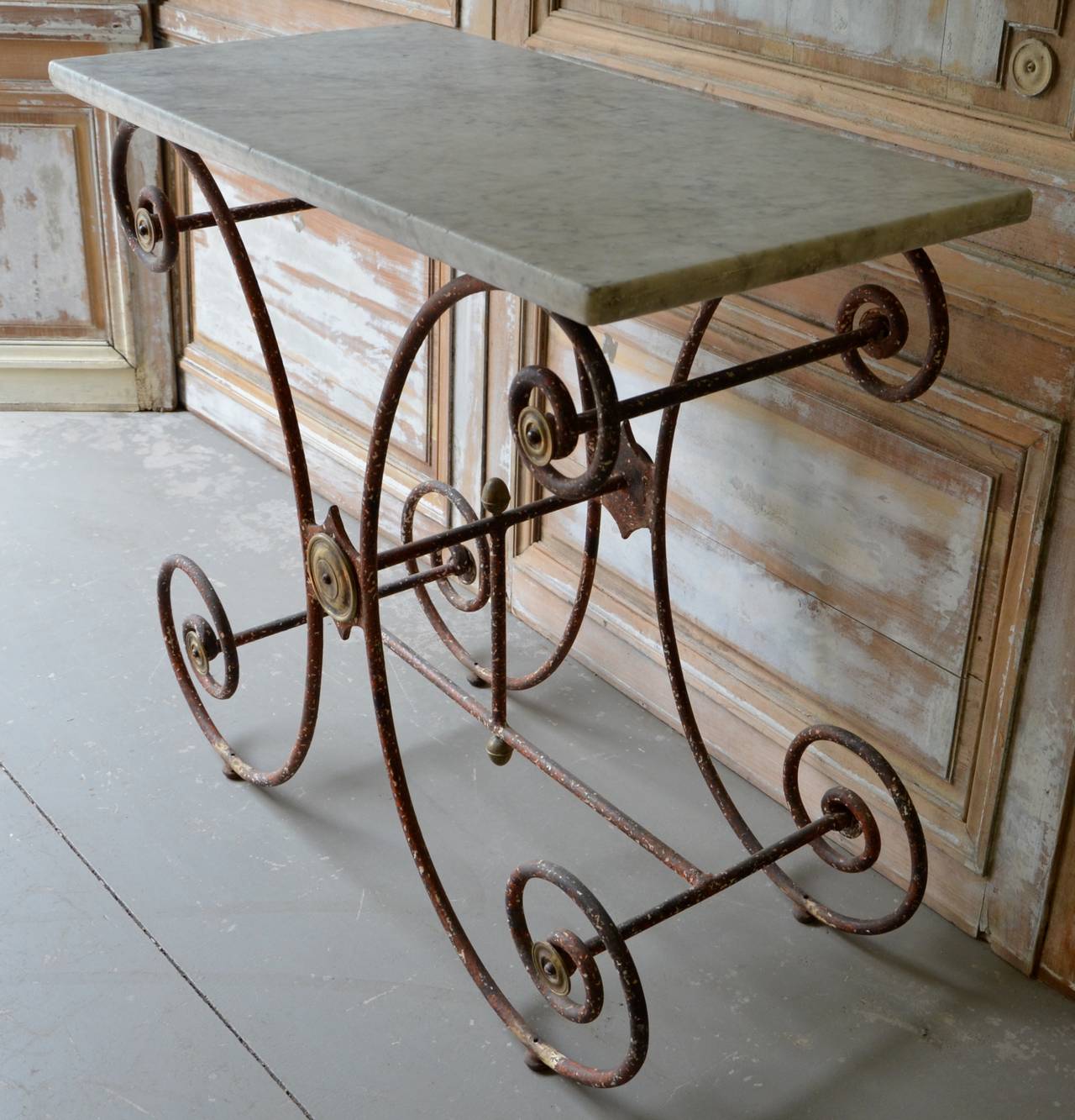 19th century French marble top pastry table with original marble top and bronze finials.
The scrolling frame has original red orange paint over the worn white paint.
 Napoleon III , France, circa 1880