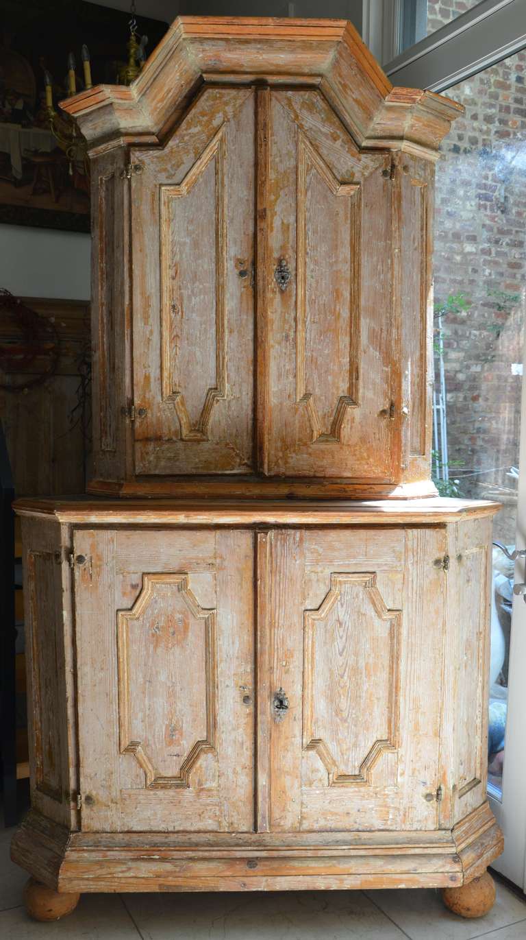 18th century Swedish Corner Cabinet in late Baroque, circa 1750 in two parts with wonderful pediment cornice and carved cupboard doors, two shelves, one shaped and notched for spoons. The original scraped blue paint inside of the upper and lower