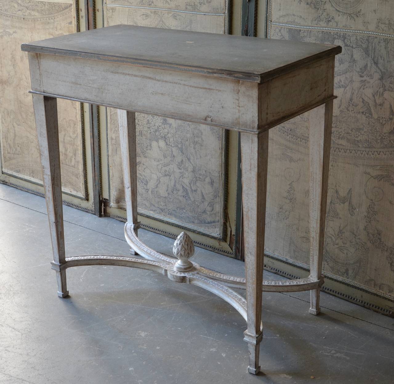 Simple Gustavian style style console table with tapered legs connected with carved shaped strecher and central pinecone motif.
Sweden circa 1840.