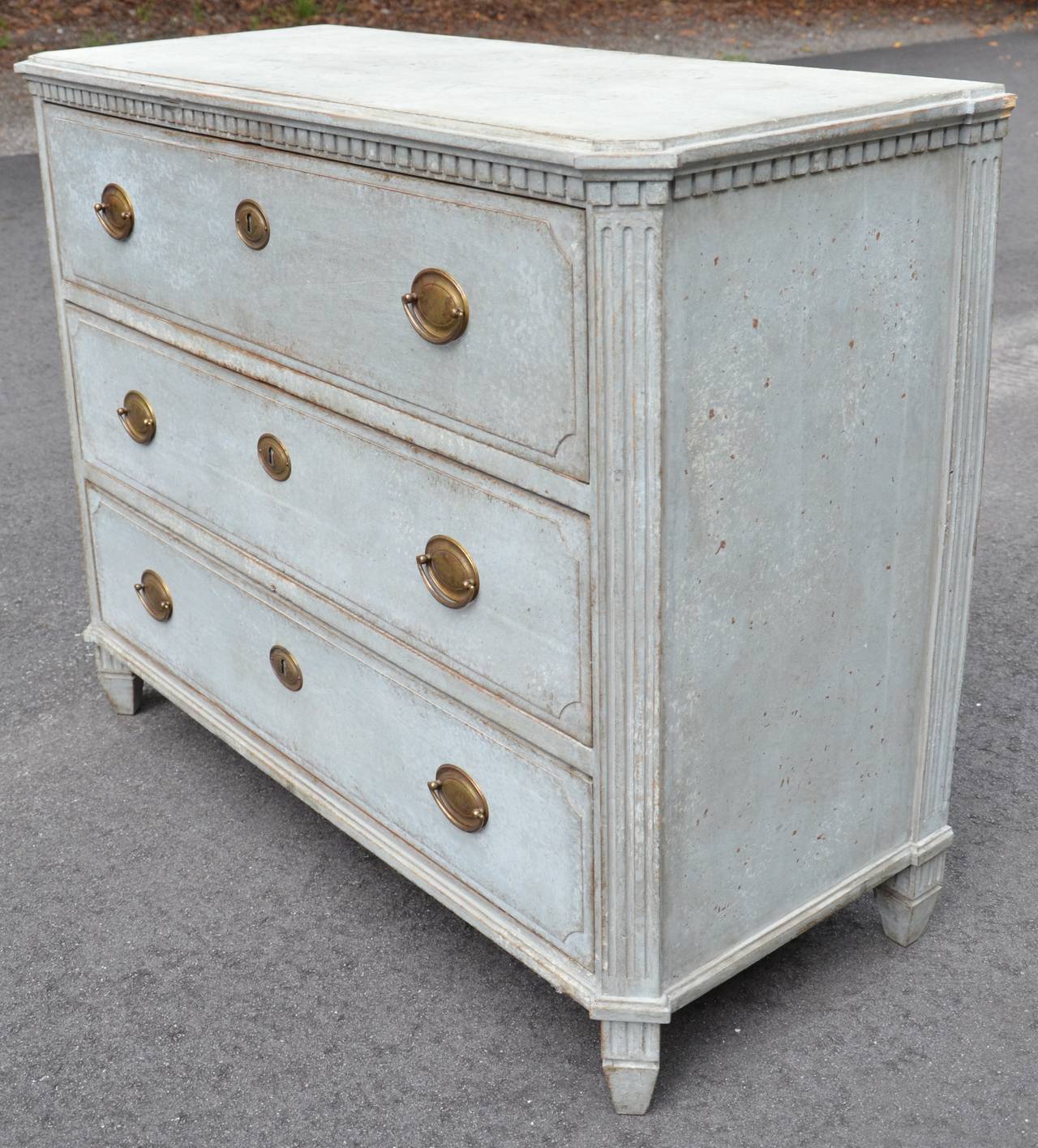 19th century Swedish Gustavian period chest with handsome brass hardware, dentil molding under the shaped top, canted corners and tapered feed in beautiful greenish blue patina.
Sweden, circa 1810.
