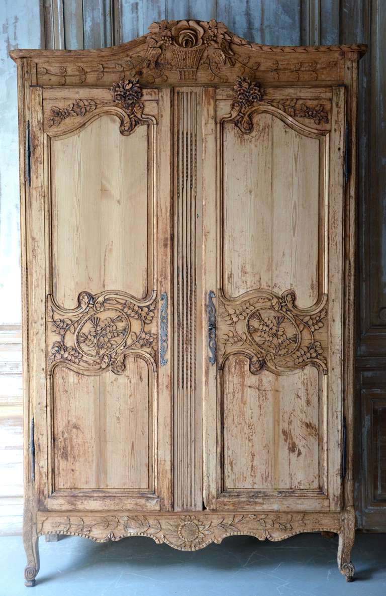 18th Century Louis XV style French Marriage Armoire in worn stripped pine wood, features one of the most popular motifs in Normandy, a pair of birds, carved in high relief to symbolize love, marriage and fidelity. It was particularly favored in the