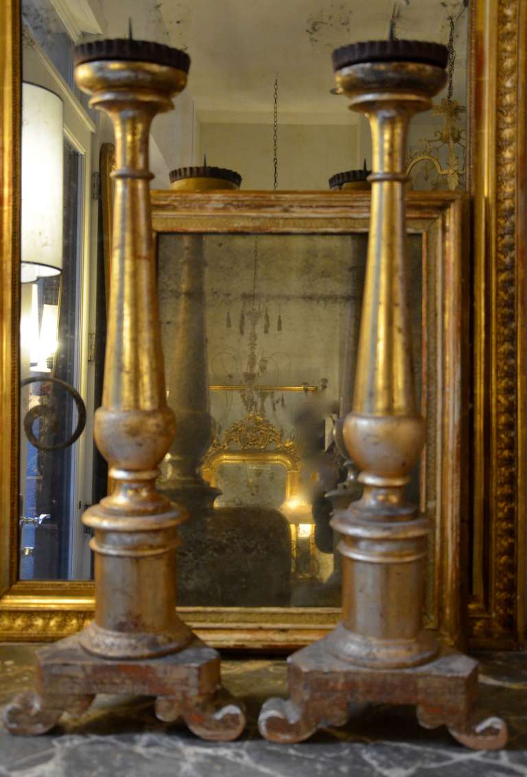 Pair of 19th century Italian Candlesticks with parcel gold on the front and back side painted with out gilding.
Original metal dripping bowls with prickets.

An altar candlestick consists of five parts: the foot, the stem, the knob about the