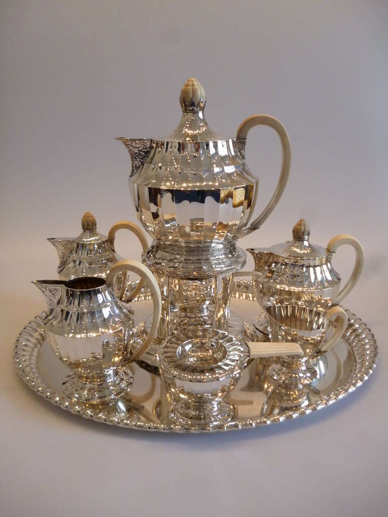Jugendstil sterling silver tea and coffee set, Vienna 1920. Designer: Otto Prutscher 1918 ( 1880-1949 ), maker: silversmith J.C. Klinkosch. Comprising big oval tray ( diameter ca. 31.5 in, 80 cm ), tea pot, coffee pot, small water pot, sugar bowl,
