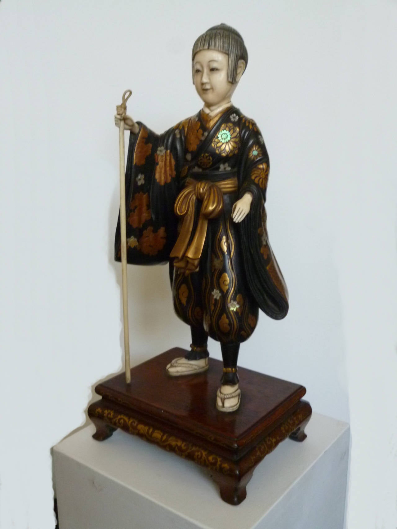 A very fine carving from Japan, Meiji period circa 1900. On rectangular wooden base. Rich gilded, with inlaid mother-of-pearl. Hands, feet, head and a pole are made of ivory. Elaborate surface decoration. Beautiful facial features.
Measures: Height