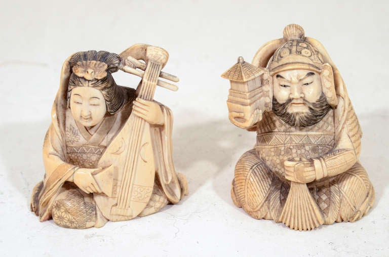 Woman playing the lute with man holding a fan and a lantern. Intricate hand carved detail.