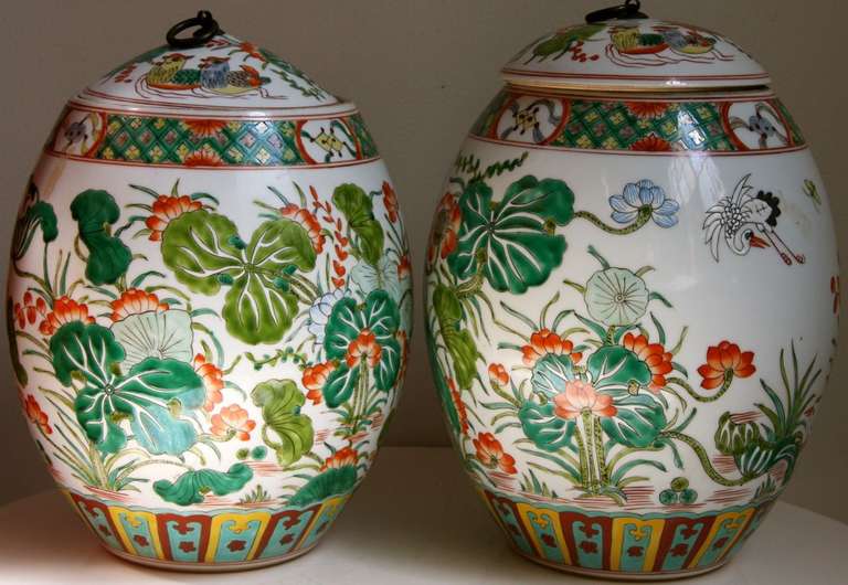 Hand painted Chinese Oriental porcelain ceramic melon shaped jars decorated with green and coral lotus leaves.Jars can be mounted as table lamps. Each cover has a bronze ring. The jars are 12 inches tall