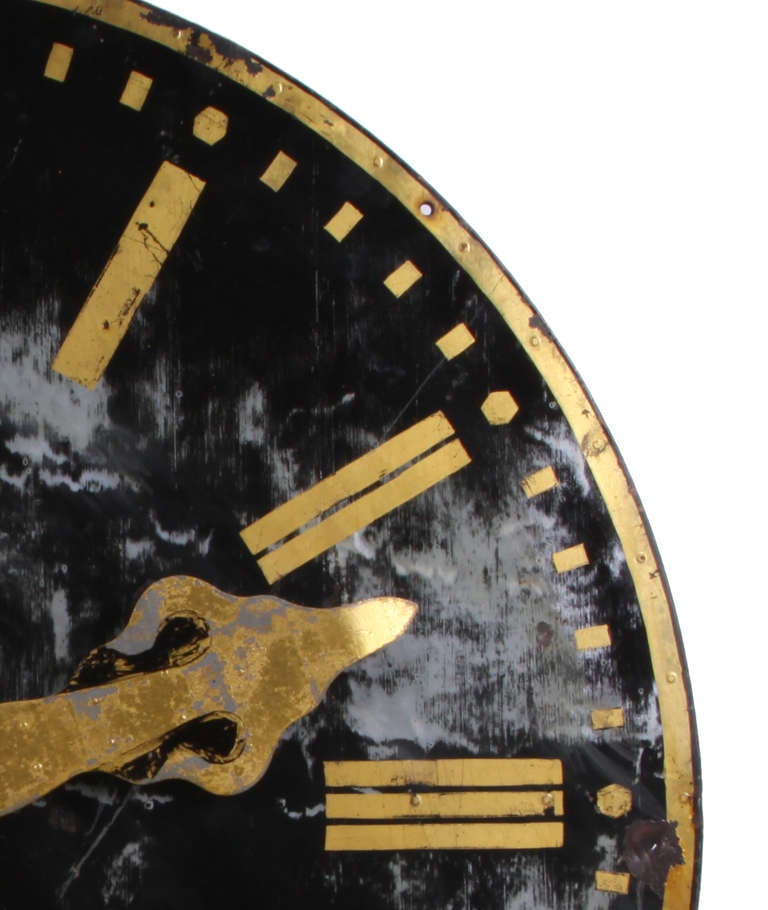 Beautiful steel clock from France, circa 1850, that once was located atop a clock tower. Painted black finish with gold accents. Some of the finish is worn away to reveal layers of use through the years and interesting bullet holes that could tell a