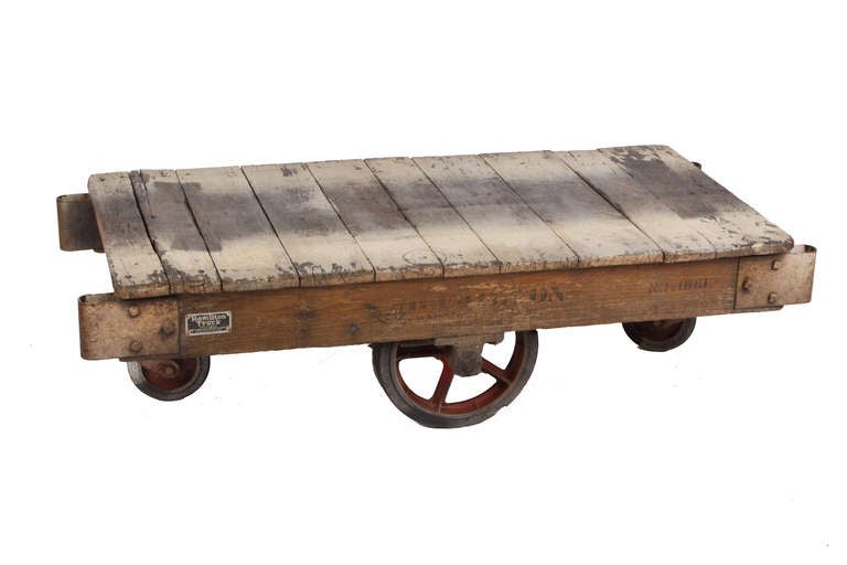 An industrial factory cart, also often referred to as cotton bale or railroad cart. Commonly used in railroad depots for transporting trunks between train cars, in textile and lumber mills for material handling, and in furniture factories for moving