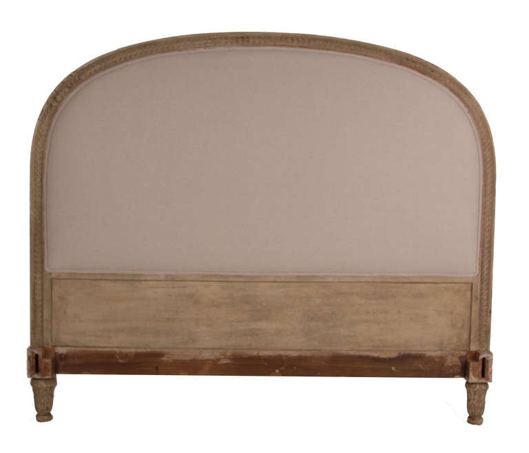 Antique bed from France, late 19th century. Upholstered headboard with intricately carved wood frame. Carved wood footboard & side rails.  Newly upholstered in a natural colored muslin, with double welting.  Front & back of headboard & footboard are